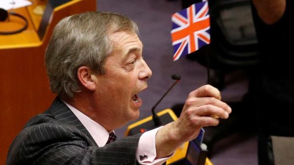 Nigel Farage waves a Unio<em></em>n Jack while speaking in the European Parliament